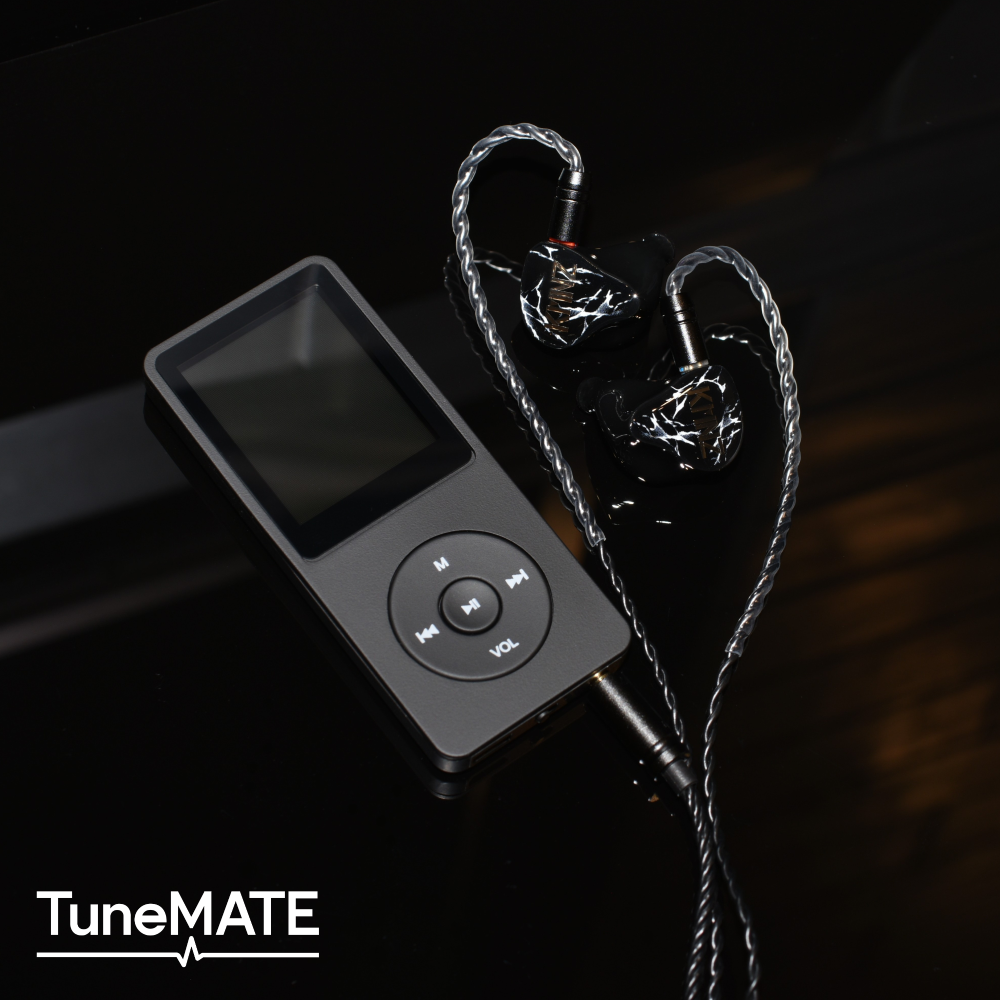 Black wired earphones with a braided silver cable placed beside a black portable music player on a dark reflective surface.