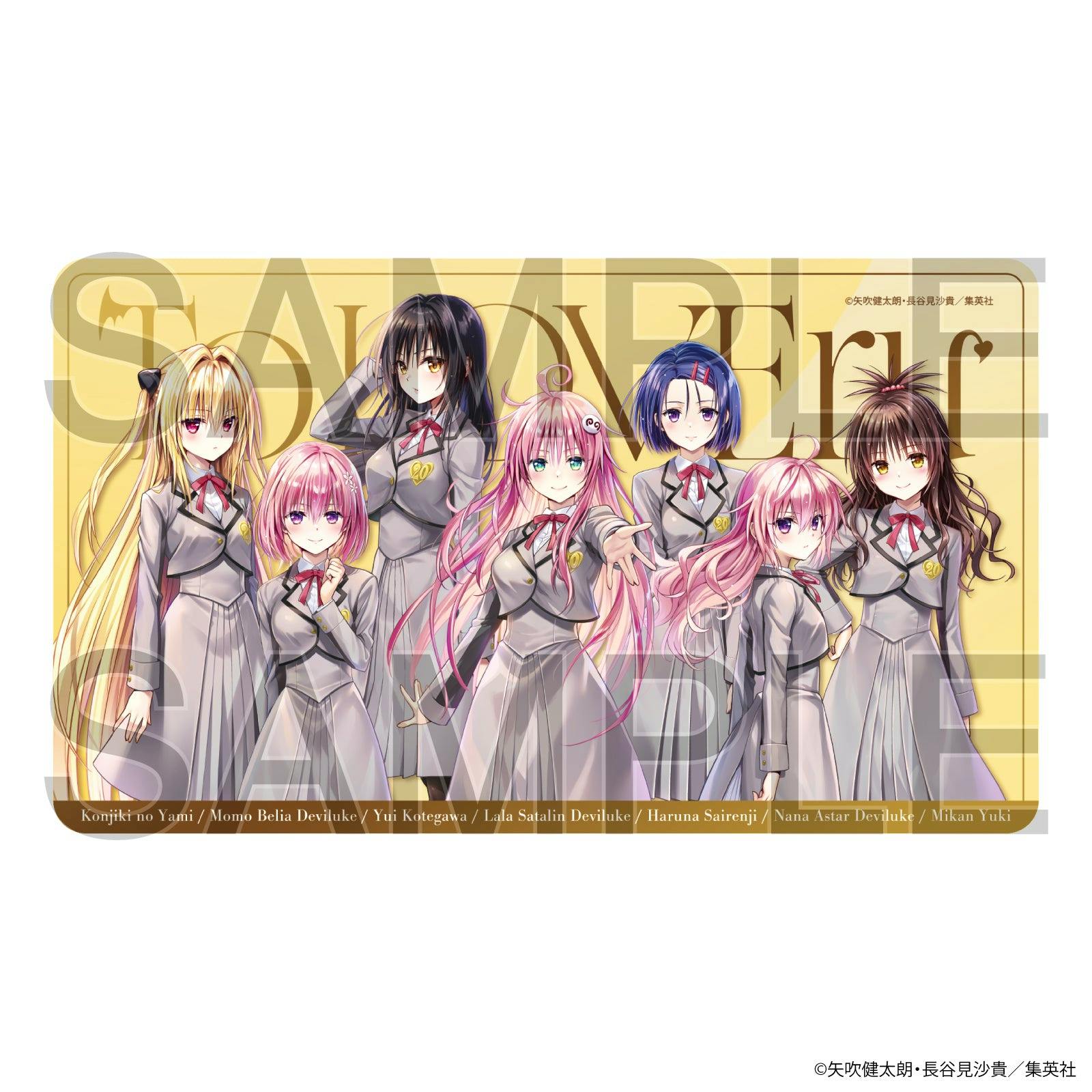 A rectangular To LOVEる 20th anniversary desk mat showing seven female characters in school uniforms on a yellow background with a large SAMPLE watermark.