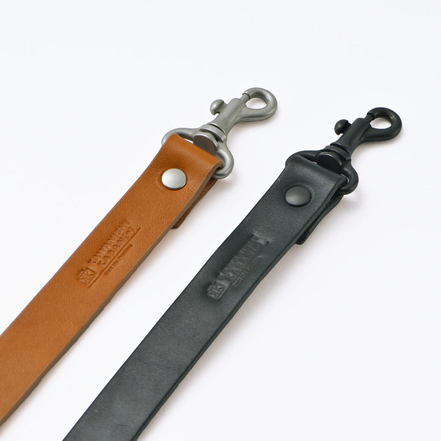 Two Tochigi cow leather 21mm shoulder strap parts in tan and black with metal swivel hooks on a white background.
