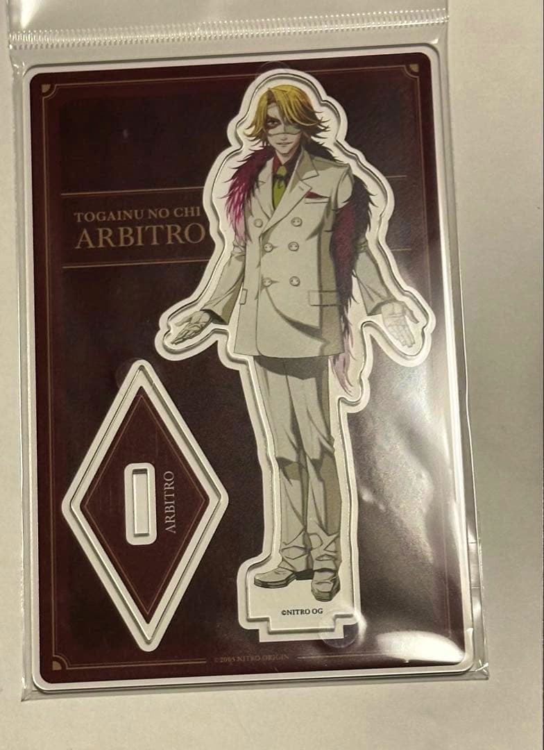 Packaged acrylic decorative stand for 咎狗の血 (Arbitro) showing the character die-cut stand and its diamond-shaped base on a backing card.