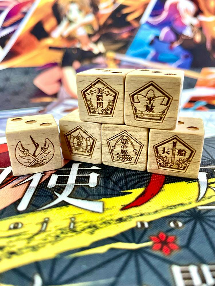 Six wooden dice engraved with character insignia and symbols arranged on an anime-themed playmat.