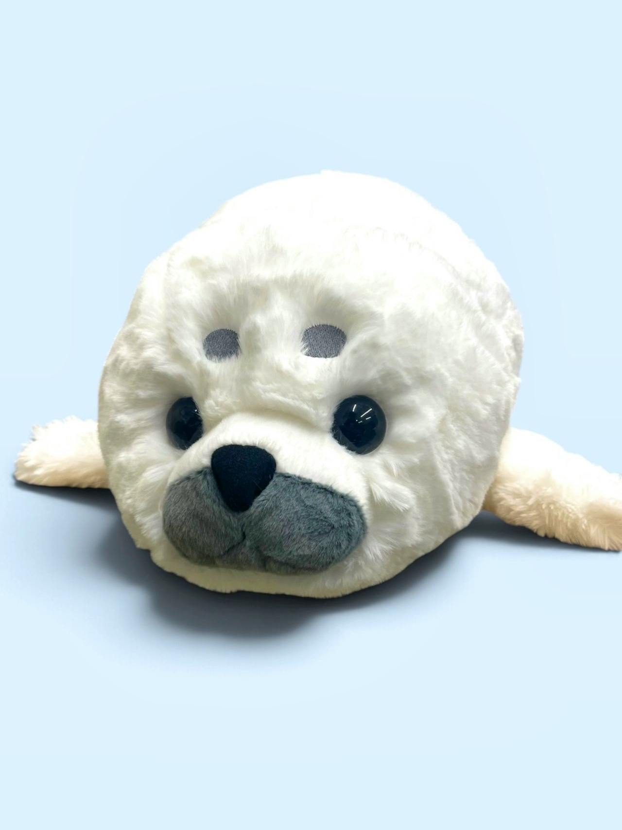 Front view of the とっかりセンター 月ちゃんBIGぬいぐるみ plush showing the seal's face and flippers on a light blue background.