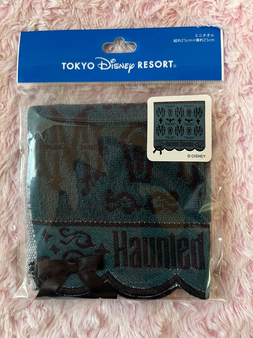 Sealed Haunted Mansion mini hand towel in its original plastic packaging with a Tokyo Disney Resort blue header card and sticker.