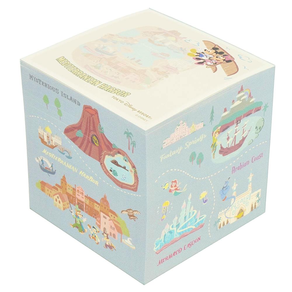 Cube memo pad showing illustrated Tokyo Disney Resort–themed panels of park areas on its sides.