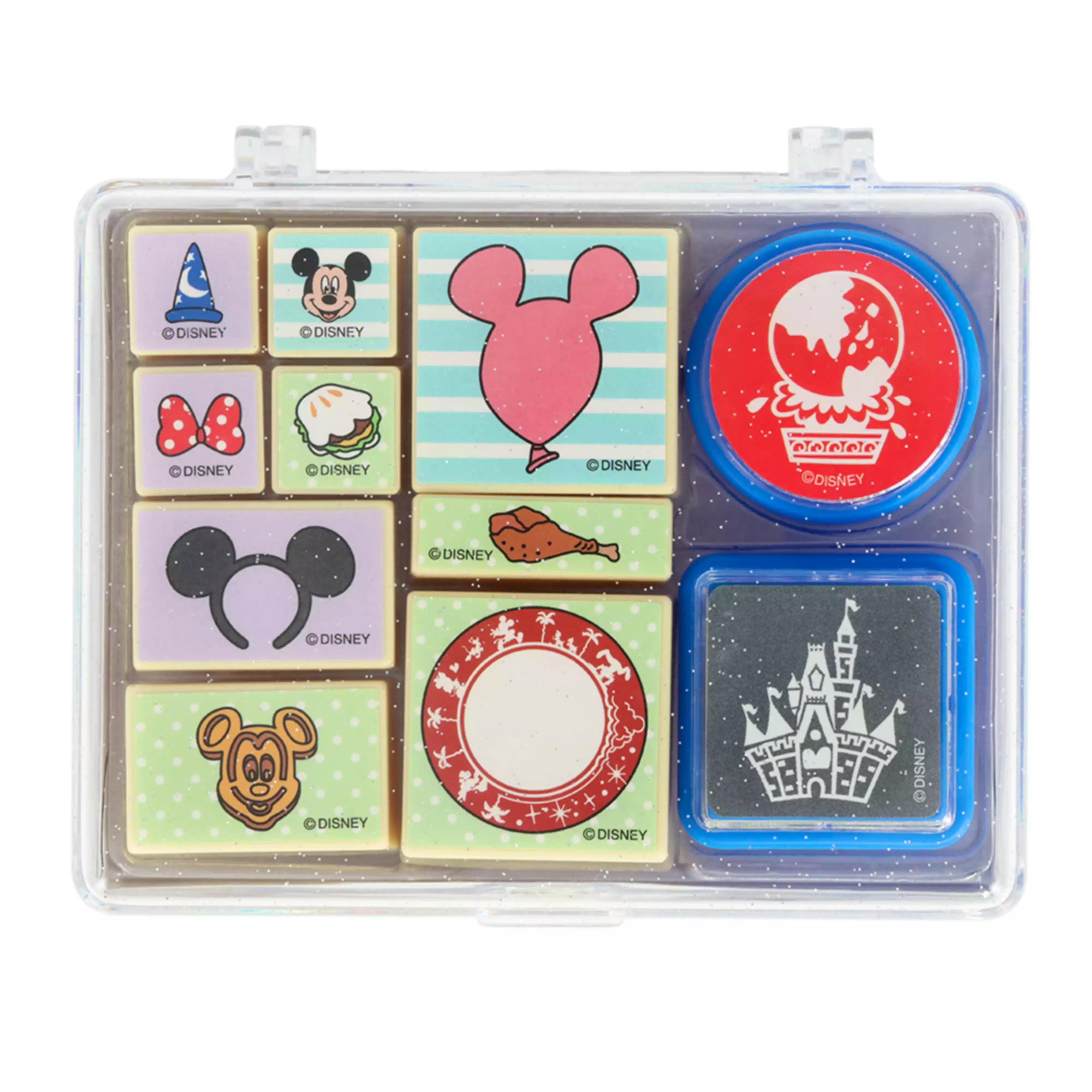 Clear plastic case containing multiple small Disney-themed stamp blocks and a round ink pad.