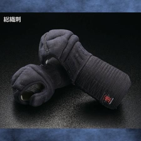 Pair of dark polyester kendo kote gloves with woven stitching displayed on a dark surface.