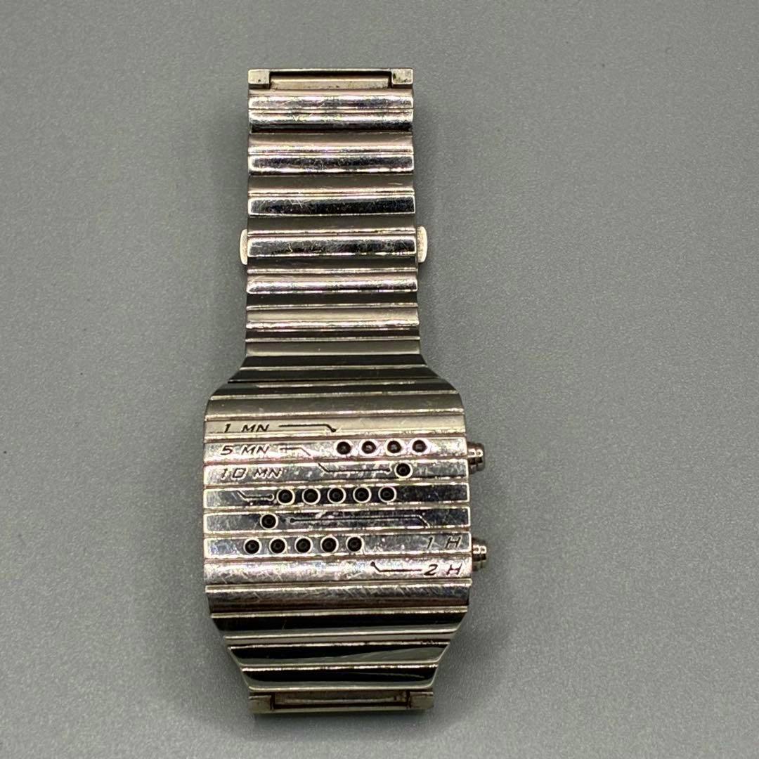 Top-down photo of a stainless Tokyoflash Ni LED wristwatch showing ribbed metal bracelet and LED indicator holes on the face.