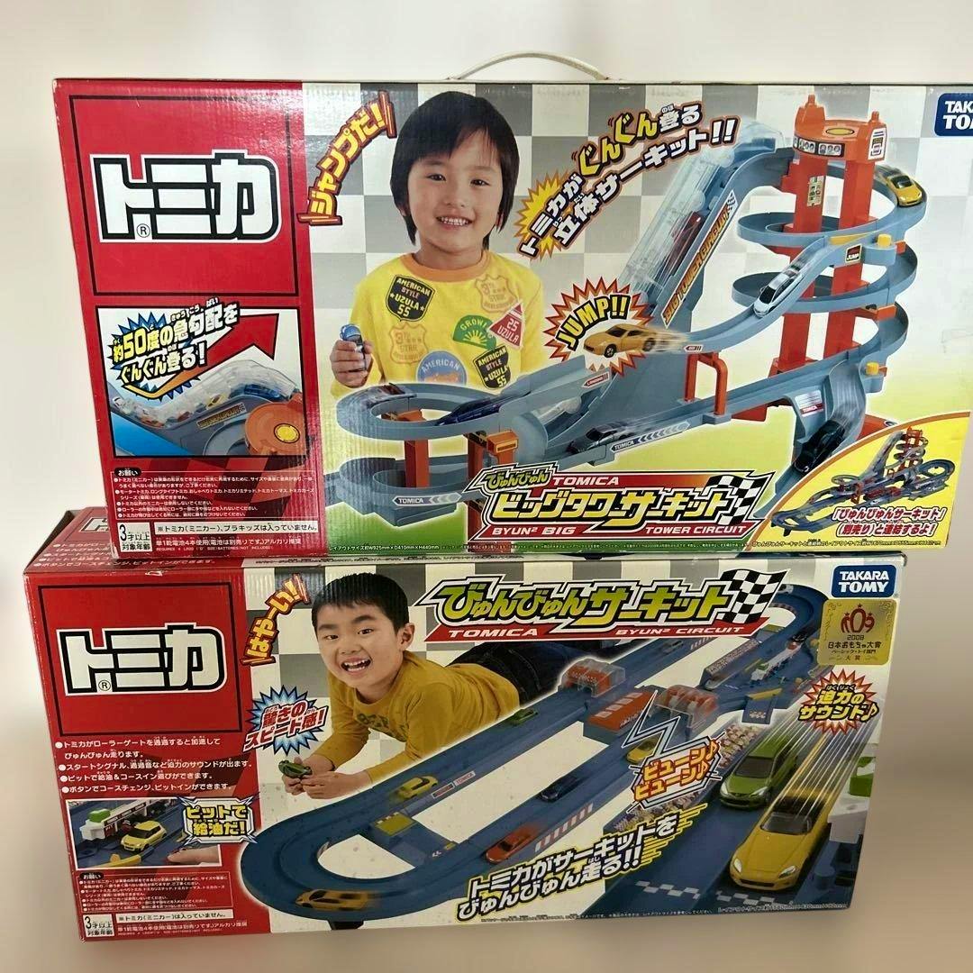 Two Tomica toy circuit boxes stacked, showing the Byun Byun Circuit and Big Tower Tower Circuit packaging.