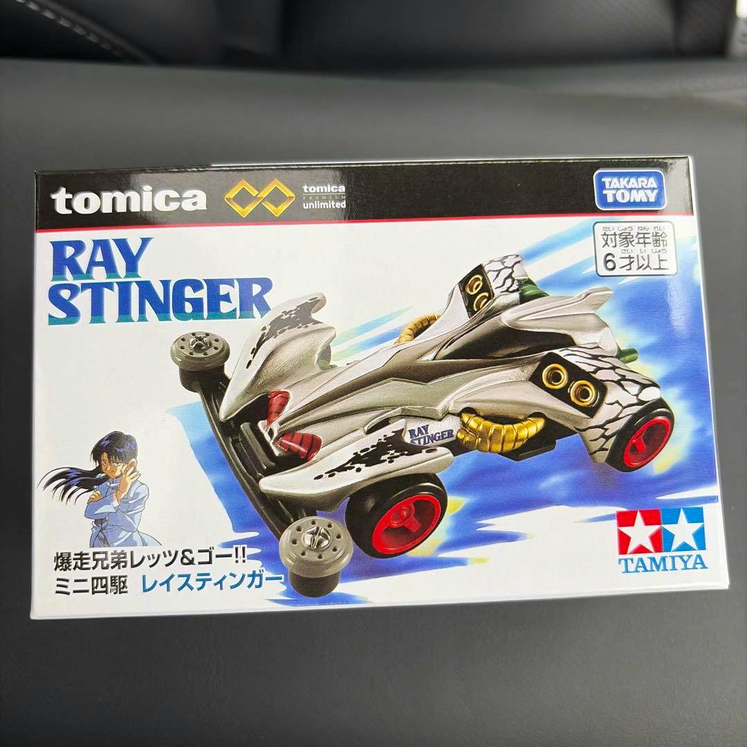 Front of the Ray Stinger Tomica Premium Unlimited box showing the toy car artwork and brand logos.