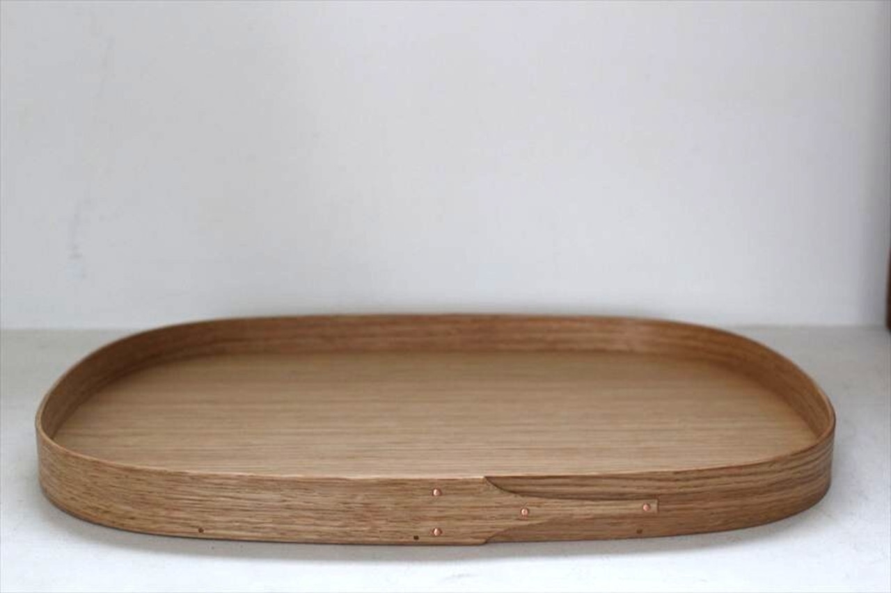 Extra-large rounded wooden tray with a low rim and visible wood grain on a plain background.
