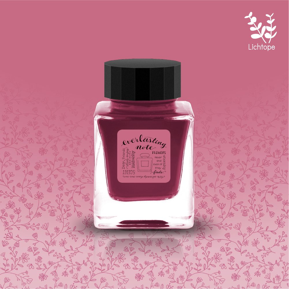 A square glass fountain pen ink bottle with a black cap and a pink "everlasting note" label on a pink floral background.