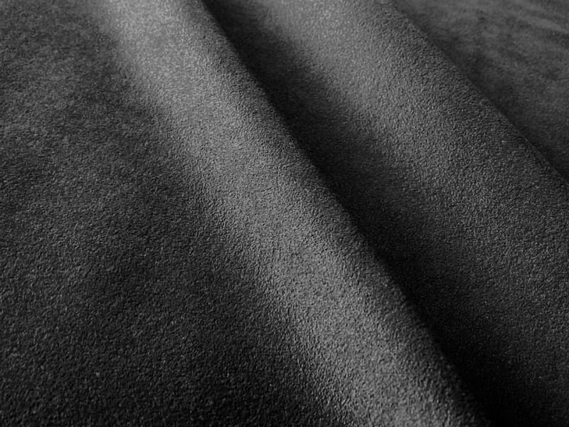 Close-up photo of black to dark gray suede-like artificial leather fabric.