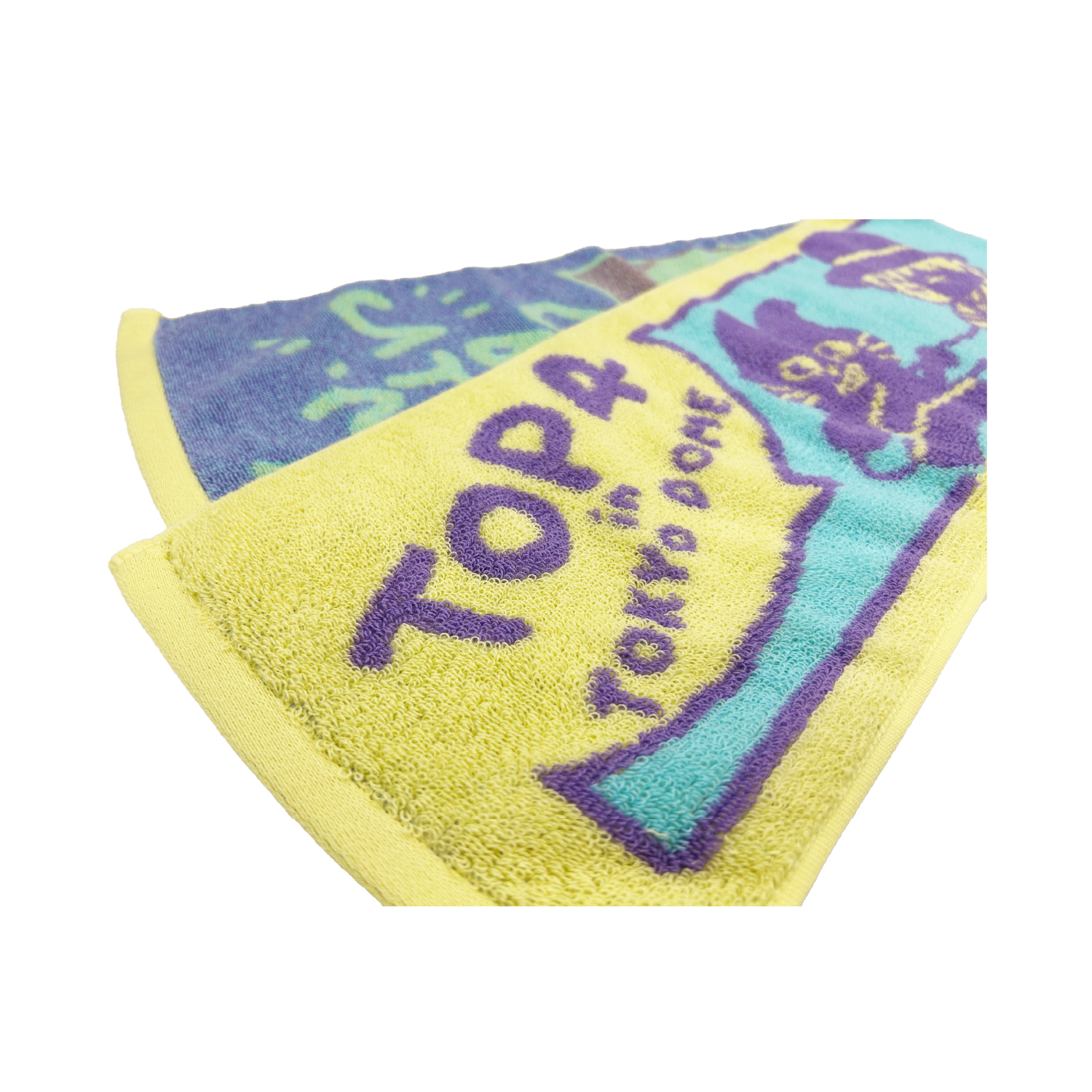 Close-up photo of the cotton hand towel showing yellow and turquoise sections with “TOP4 in TOKYO DOME” text and character graphics.