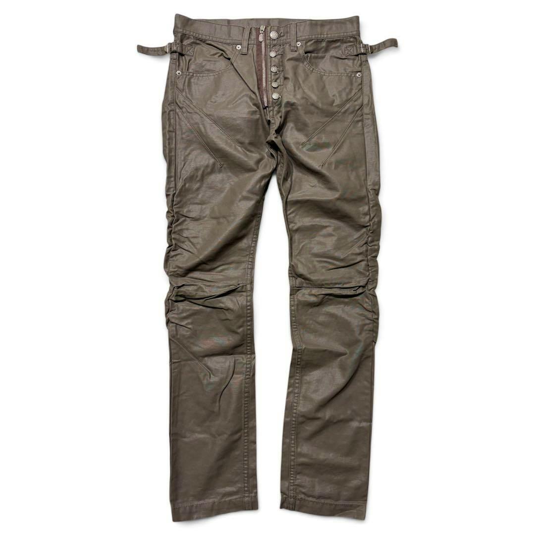 Front view of TORNADO MART brown coated biker pants laid flat showing button-fly, pockets, and knee detailing.
