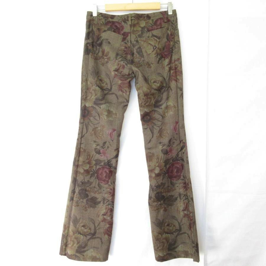 Back view of khaki floral flared women's pants hanging on a hanger against a white background.