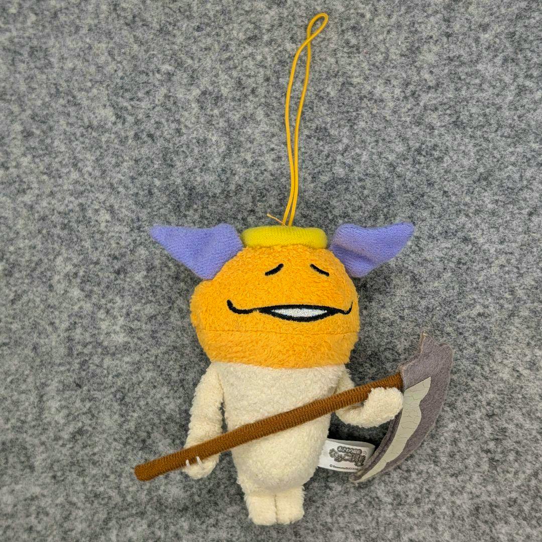 Full-body photo of the おさわり探偵なめこ 天使なめこ plush mascot showing an orange head with purple ears, a yellow halo loop, and a fabric weapon accessory.