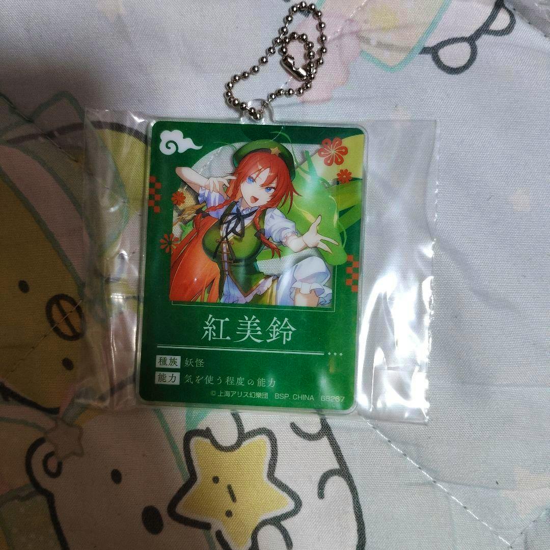 Sealed acrylic keychain showing the Touhou Project 一番くじ G賞 紅美鈴 illustration on a green background with a silver ball chain.