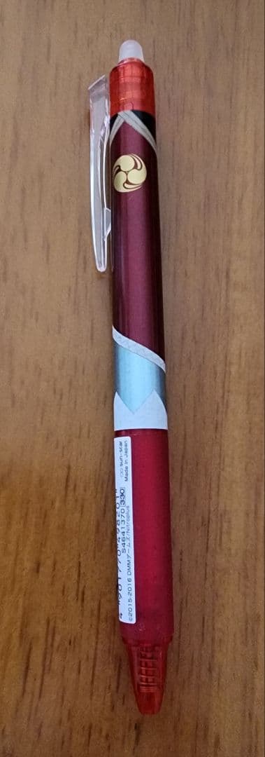 A Friction ballpoint pen with Izuminokami Kanesada design lying on a wooden surface.
