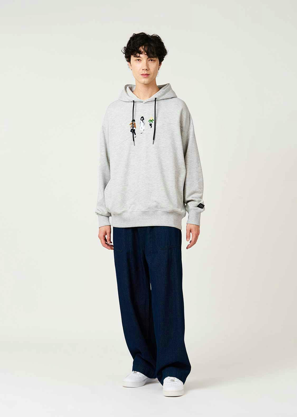 Model wearing a light gray cotton hoodie with black drawstrings and a small printed illustration on the chest.
