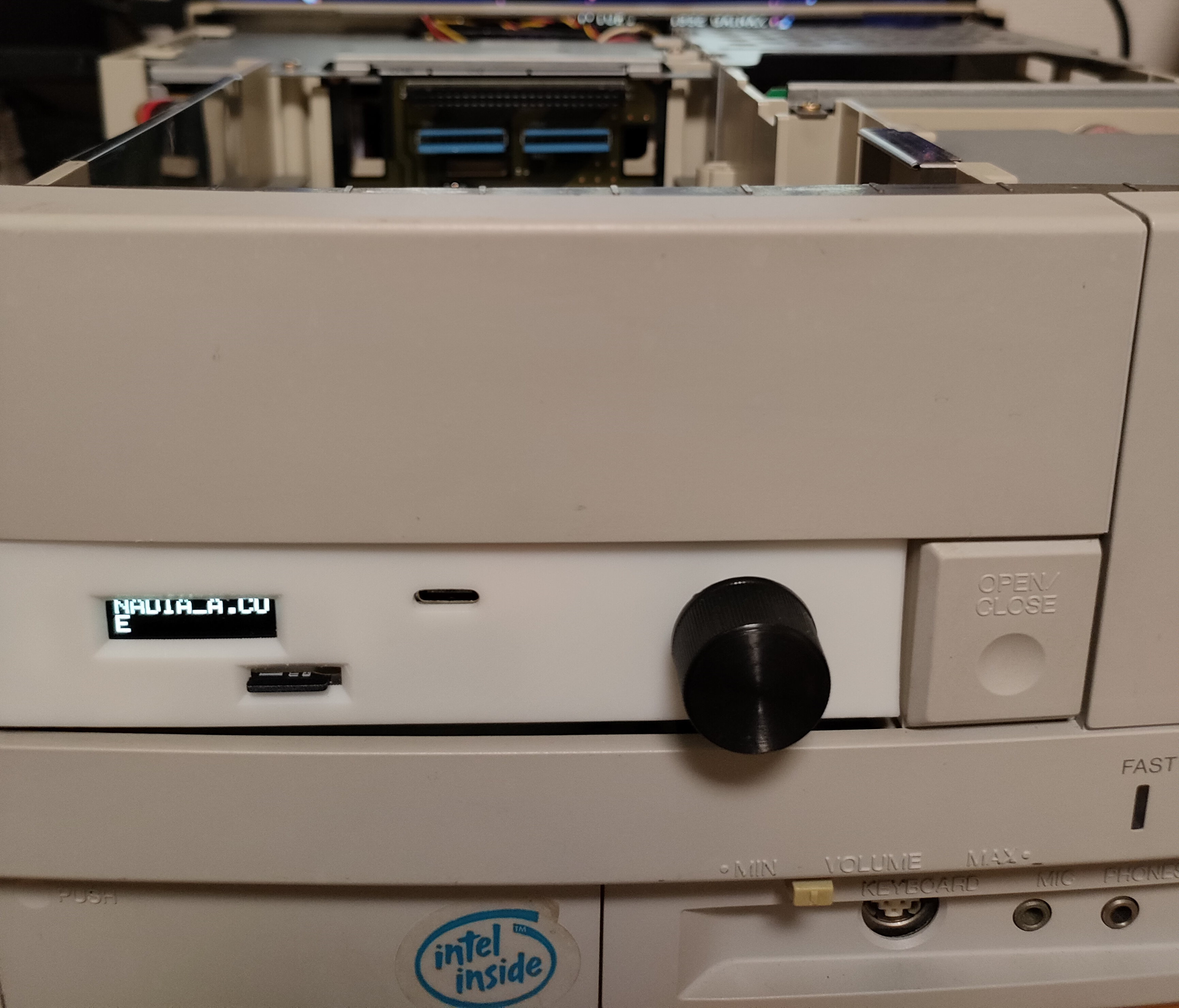 Front of an FM TOWNS drive bay showing the TOWNS ODE unit with a small lit text display, a black rotary knob, and an OPEN/CLOSE button.