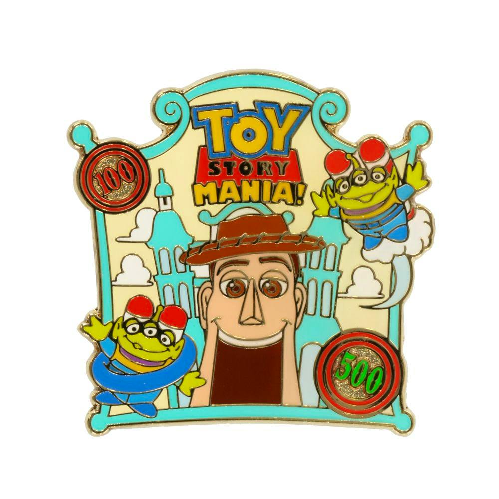 Enamel pin badge showing the "Toy Story Mania!" logo with Woody's face and two green aliens on a white background.