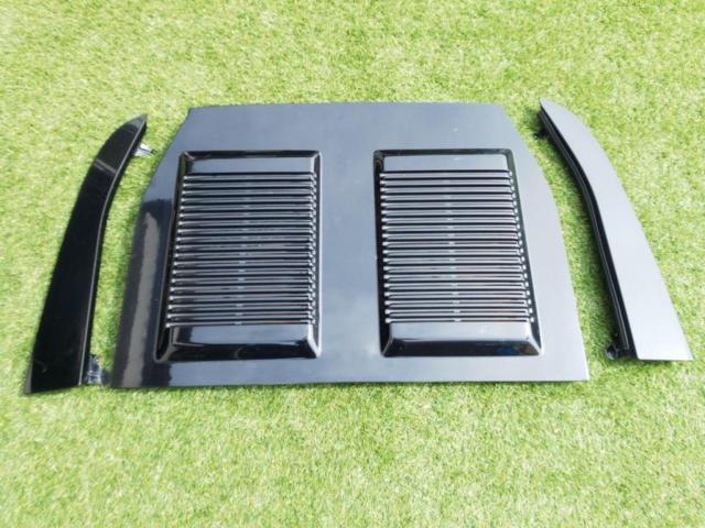 Toyota MR2 SW20 black engine hood with twin vented sections and two side panels displayed on grass.