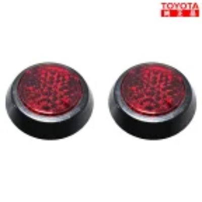 Two round red Toyota reflex reflectors with black housings shown side by side.