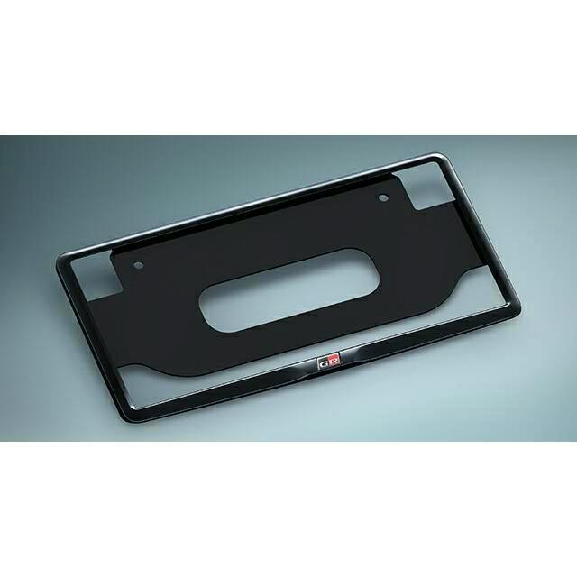 Black front license plate frame for GR Corolla with a small GR emblem shown on a gray background.