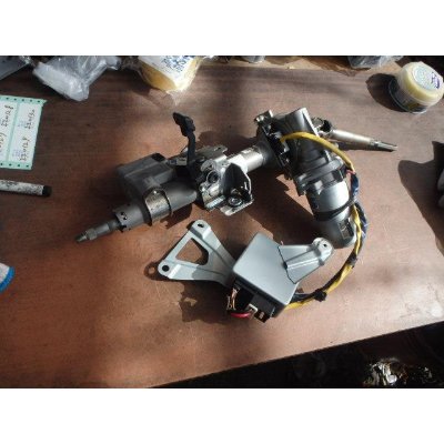Steering column / steering box assembly with wiring harness and mounting bracket laid out on a workbench.