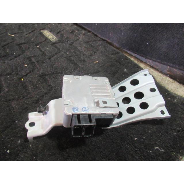 Power steering computer module with mounting bracket and electrical connector shown on a carpeted surface.