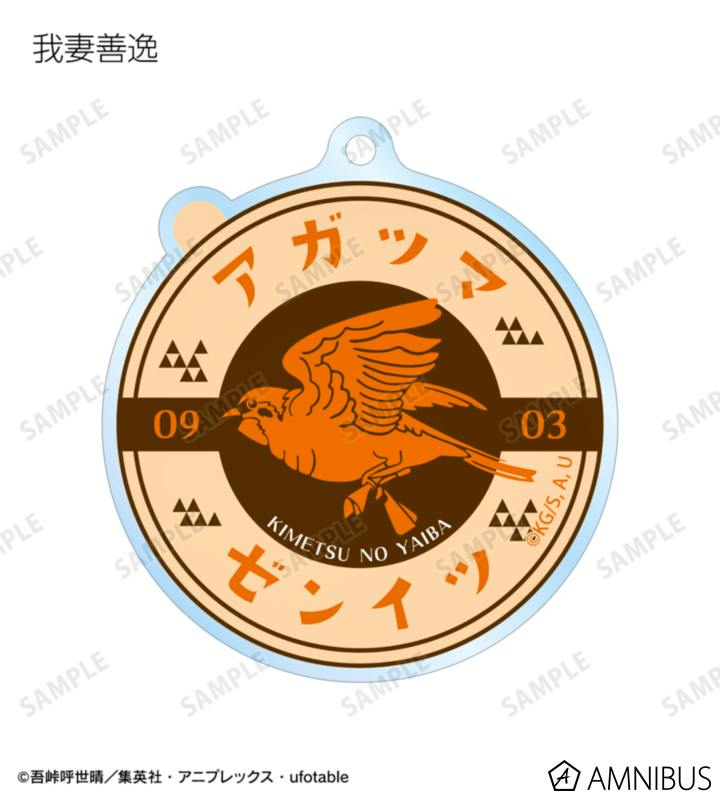 Round acrylic keychain resembling a milk-bottle cap featuring an orange bird motif and Japanese text.