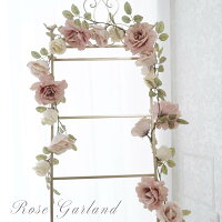 Pink artificial rose garland draped around a window frame used as a decorative display.