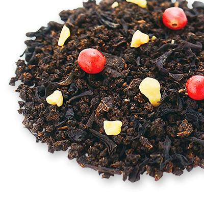 Close-up of loose black tea leaves mixed with small red and yellow decorative pieces on a white background.