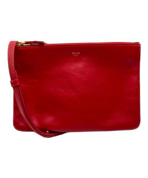 Red leather small shoulder pouch with a strap and top zipper shown on a white background.