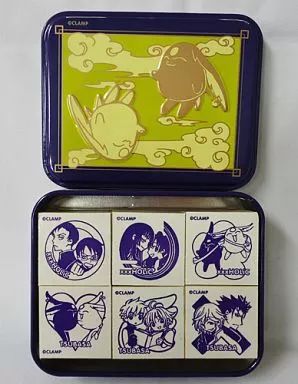Open decorative tin showing six stamps with character illustrations from Tsubasa & xxxHOLiC.