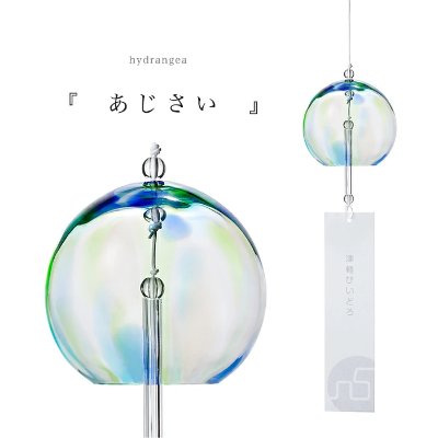 Round glass wind chime with a clear clapper and a hanging rectangular paper strip.