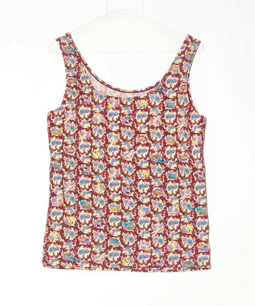 Red sleeveless women’s singlet with an all-over multicolored patterned print displayed on a hanger.