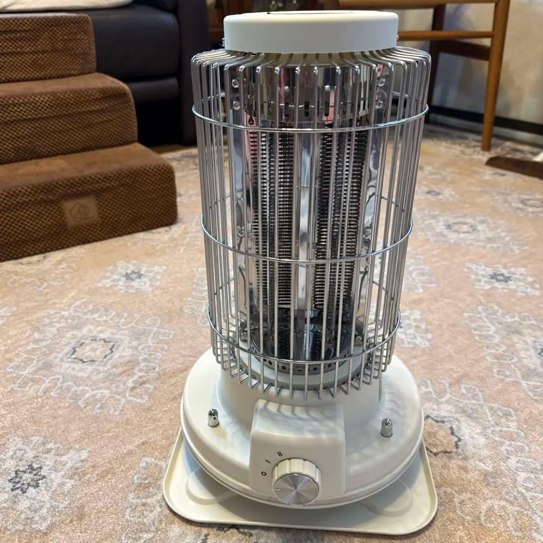 Front view of the white electric heater TT-HM-D005 showing its cylindrical metal guard and front control knob on a floor.