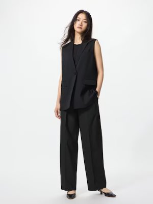 Model wearing black tuck wide pants shown full-length.