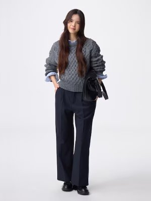 A woman wearing the women's polyester wide pants, shown full-length with a sweater and bag.