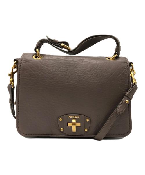 Front view of the cow leather turn-lock satchel bag showing a top handle, shoulder strap, and gold-tone turn-lock closure.