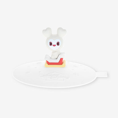 Plastic mug cap consisting of a round lid with an attached small white character figurine.