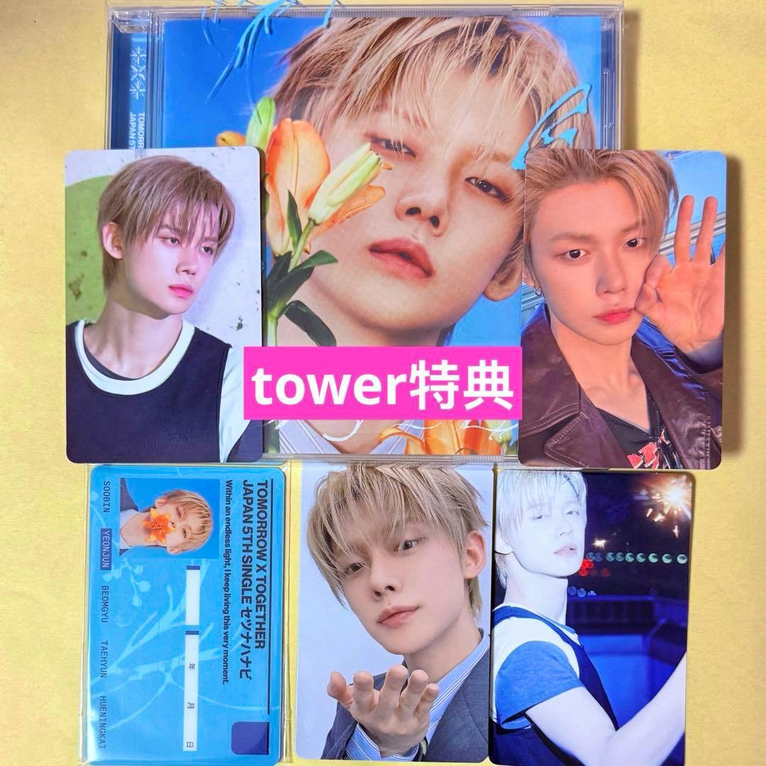 Flat lay of a CD album and six collectible photo cards on a yellow background, showing a close-up album cover and several portrait photo cards.