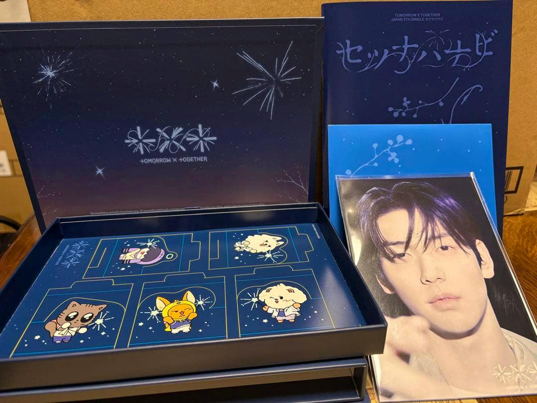Opened Japan single set showing a TXT photobook and box, character card tray, and a large member photo print.