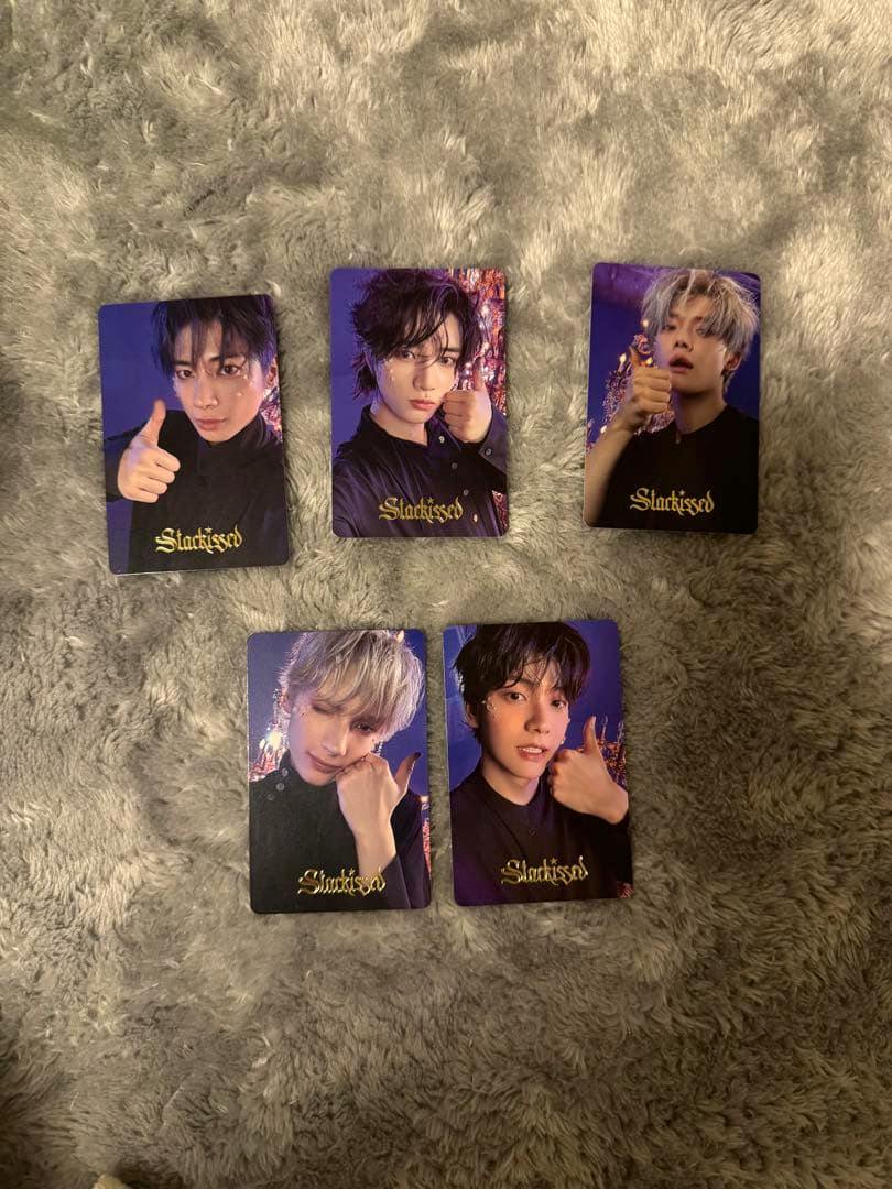 Five TXT "Starkissed" photocards arranged on a gray plush surface.