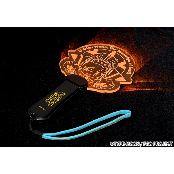 Handheld light showing an illuminated character-shaped acrylic panel attached to a black handle with a blue wrist strap on a black background.