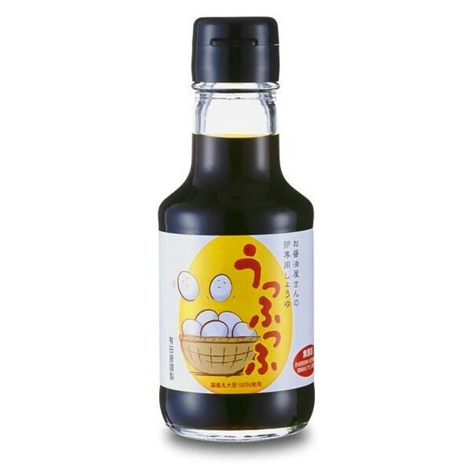 Front view of a glass bottle of soy sauce with a white label showing a basket of eggs and Japanese text.