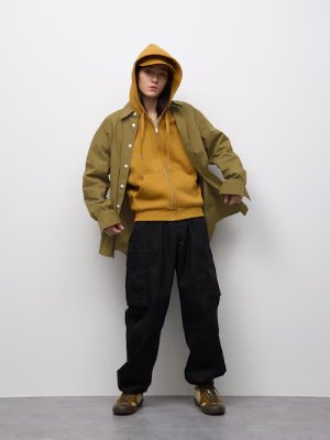 Model wearing wide cargo pants styled with layered outerwear against a white background.