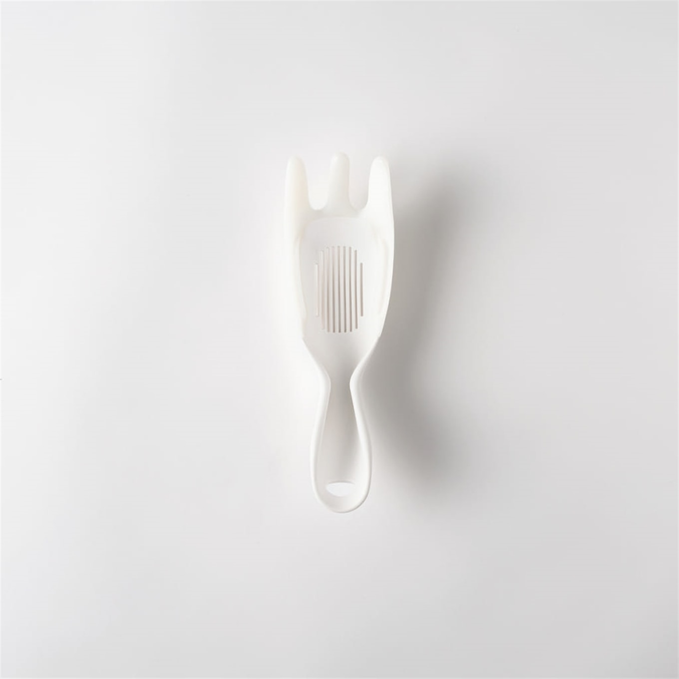 White plastic spoon with forked tines and slotted bowl shown on a plain white background.