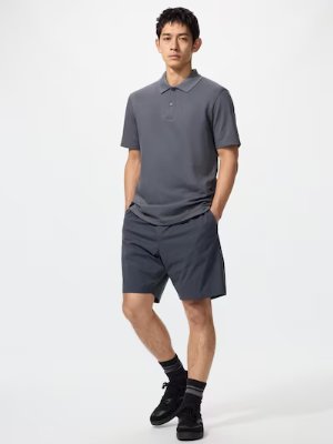 Male model wearing the men's polyester shorts in dark gray, shown paired with a short-sleeve polo.